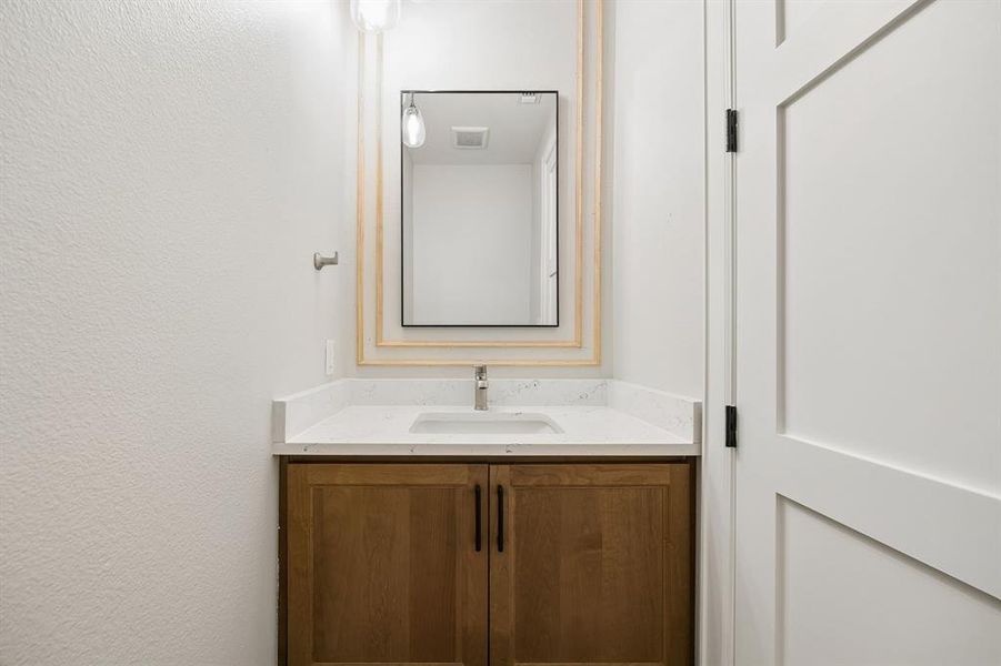 Bathroom with vanity and a textured wall Bathroom with vanity and a textured wall