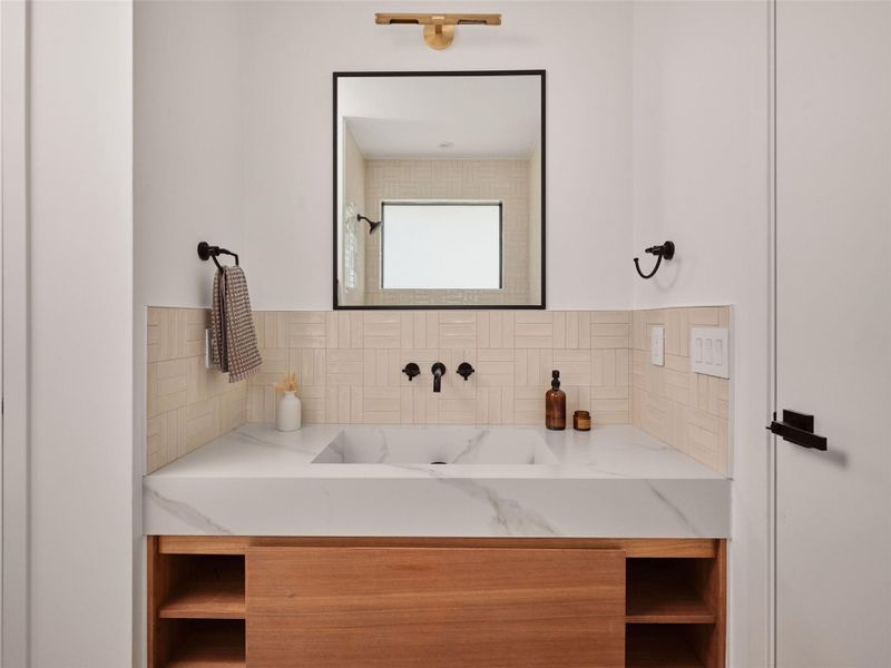 Bathroom with vanity and tasteful backsplash