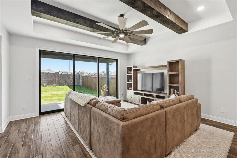 Living room featuring dark wood-style floors, beam ceiling, a ceiling fan, and recessed lighting