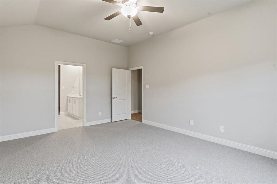 This room features light grey carpeting, light grey walls, and a ceiling fan with an integrated light fixture