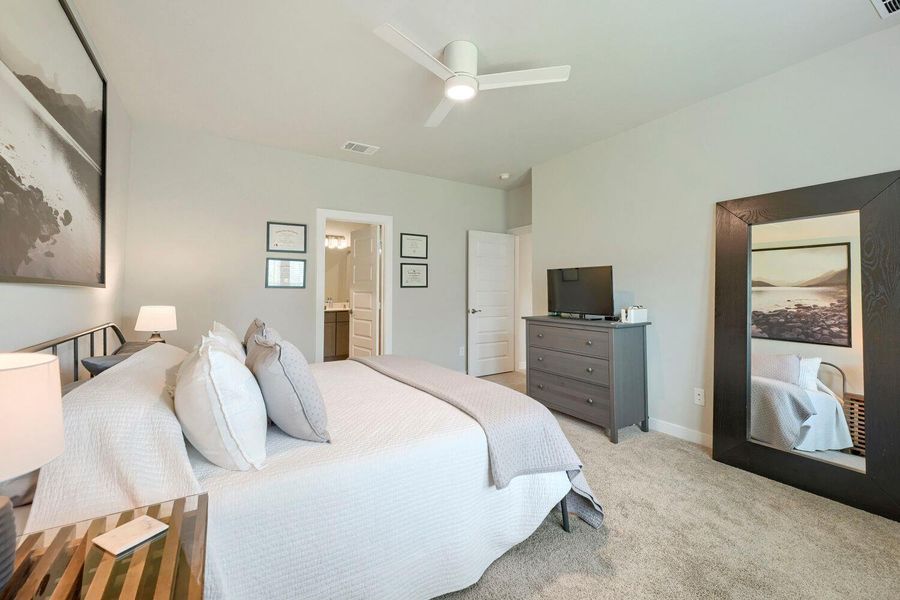 A well-appointed sleeping sanctuary awaits, featuring plush carpeting and a spacious layout leading to a private bathroom. A well-appointed sleeping sanctuary awaits, featuring plush carpeting and a spacious layout leading to a private bathroom.