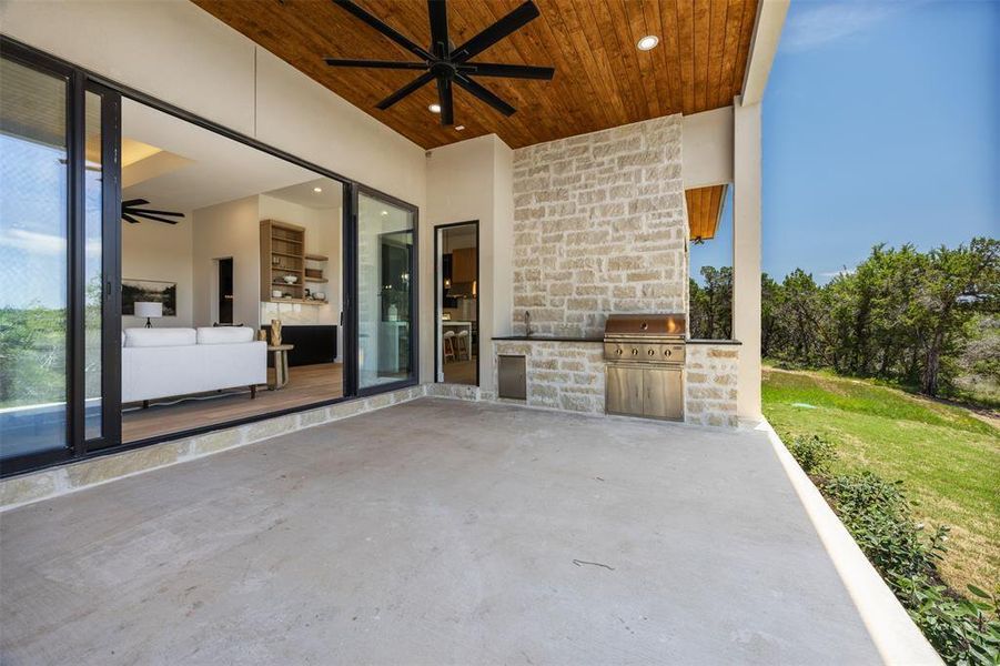 An inviting outdoor kitchen area on a covered patio provides seamless indoor-outdoor living.