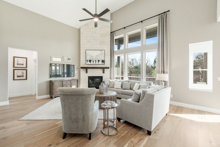 Living room with vaulted ceiling, stone fireplace, gray sectional sofa, and hardwood floors Living room with vaulted ceiling, stone fireplace, gray sectional sofa, and hardwood floors