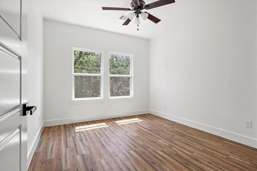 Empty room featuring wood finished floors and a ceiling fan