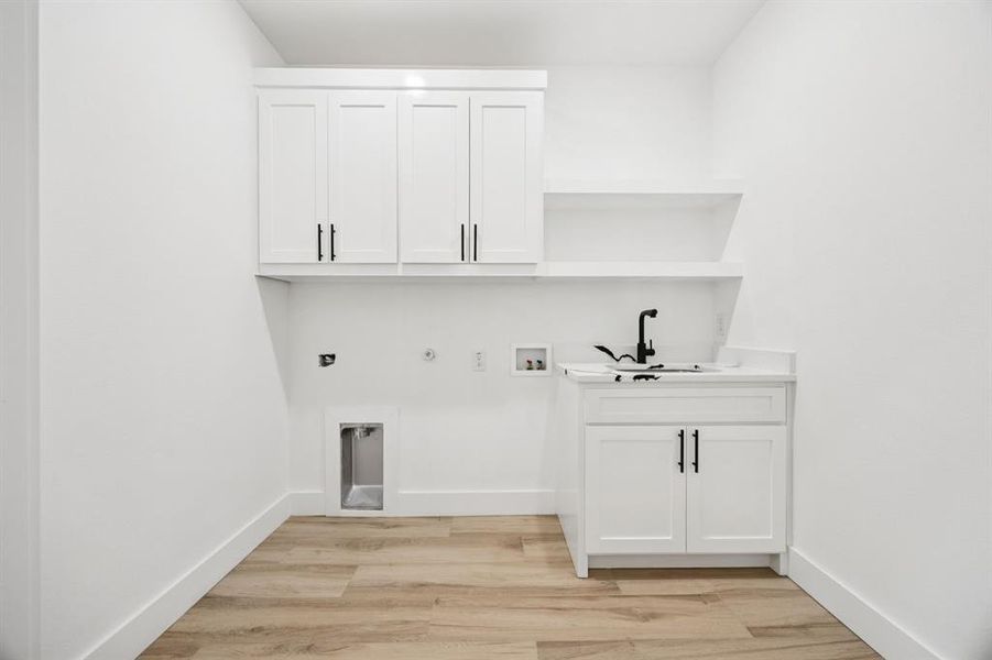Laundry room featuring gas dryer hookup, cabinet space, hookup for a washing machine, and light wood-style floors
