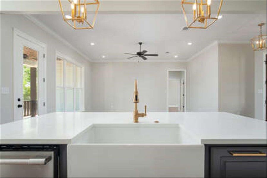 Kitchen with a chandelier, hanging light fixtures, crown molding, open floor plan, and stainless steel dishwasher