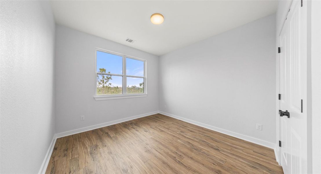 Unfurnished bedroom with wood finished floors and a closet