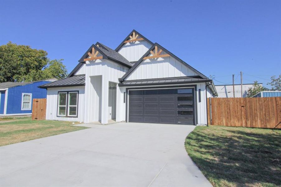 Modern inspired farmhouse featuring a standing seam roof, board and batten siding, and a metal roof Modern inspired farmhouse featuring a standing seam roof, board and batten siding, and a metal roof