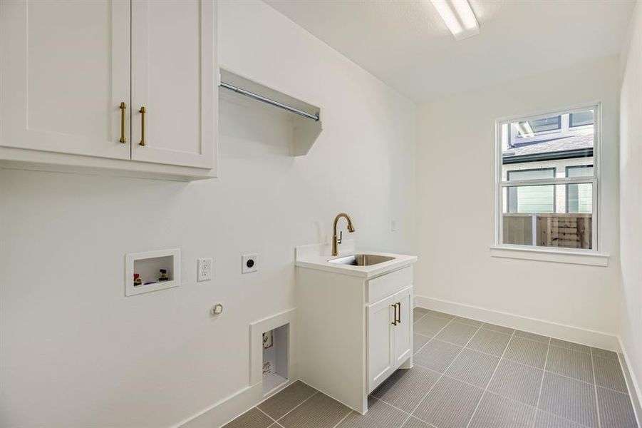 Laundry room featuring cabinet space, gas dryer hookup, light tile patterned flooring, and washer hookup Laundry room featuring cabinet space, gas dryer hookup, light tile patterned flooring, and washer hookup