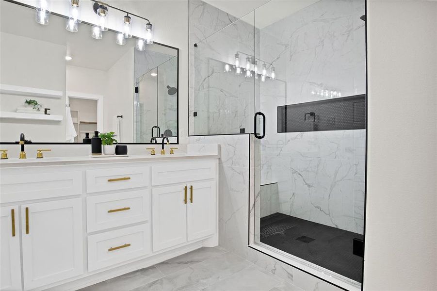 Bathroom featuring a shower with door and vanity