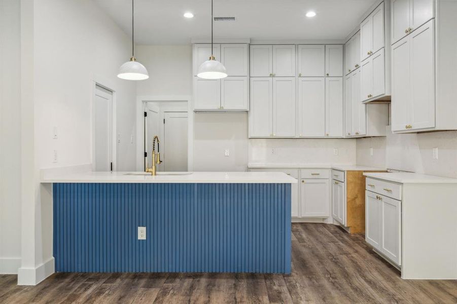 Stylistic kitchen has a ton of cabinet space, including high storage and a breakfast counter.