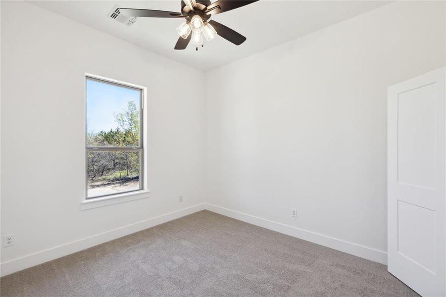 Carpeted empty room featuring ceiling fan