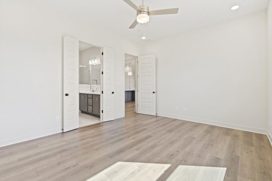 Unfurnished bedroom featuring ceiling fan, light wood-style floors, connected bathroom, and recessed lighting