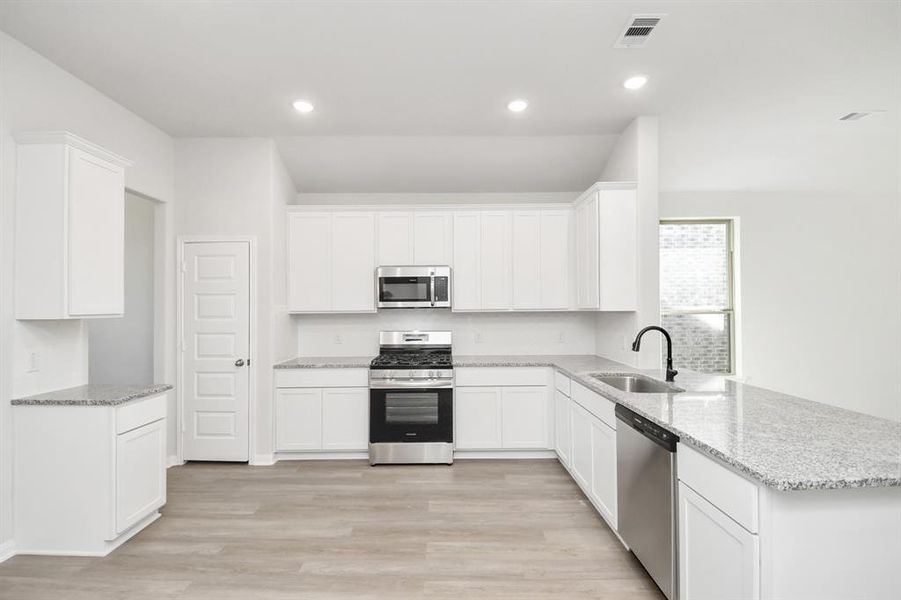 This kitchen is by far any chef’s dream! This spacious kitchen features high ceilings, lightstained wood cabinets, granite countertop, SS appliances, modern tile backsplash, recessed lighting, extended counter space, and a walk-in pantry all overlooking your huge family room.