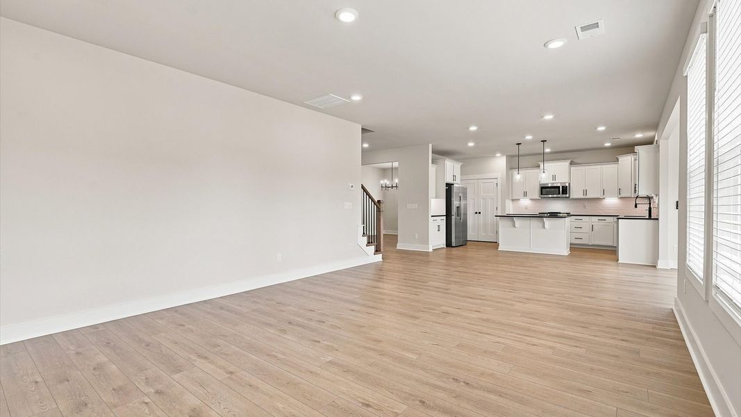 Spacious family room with rich hardwood flooring and elegant trim work in a reputable DRB Homes build