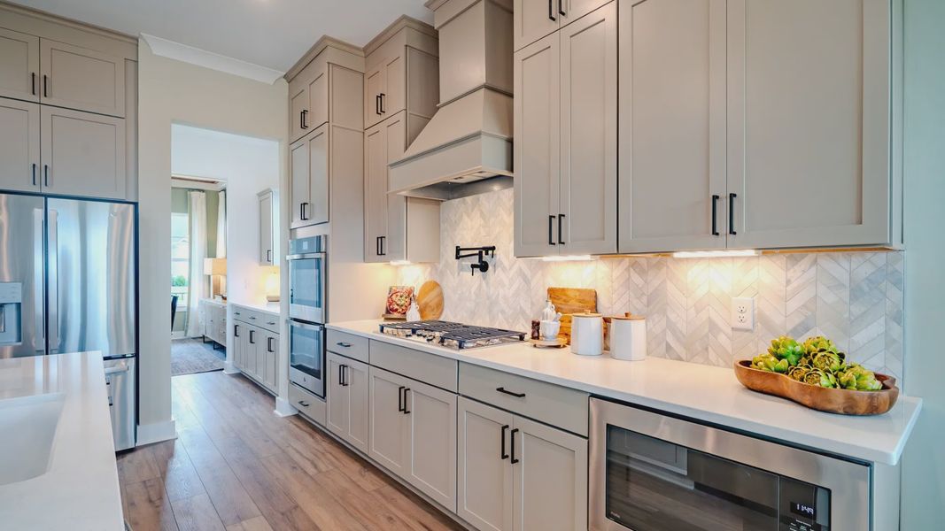 Kitchen with tile backsplash, quartz countertops, and stainless-steel appliances Kitchen with tile backsplash, quartz countertops, and stainless-steel appliances