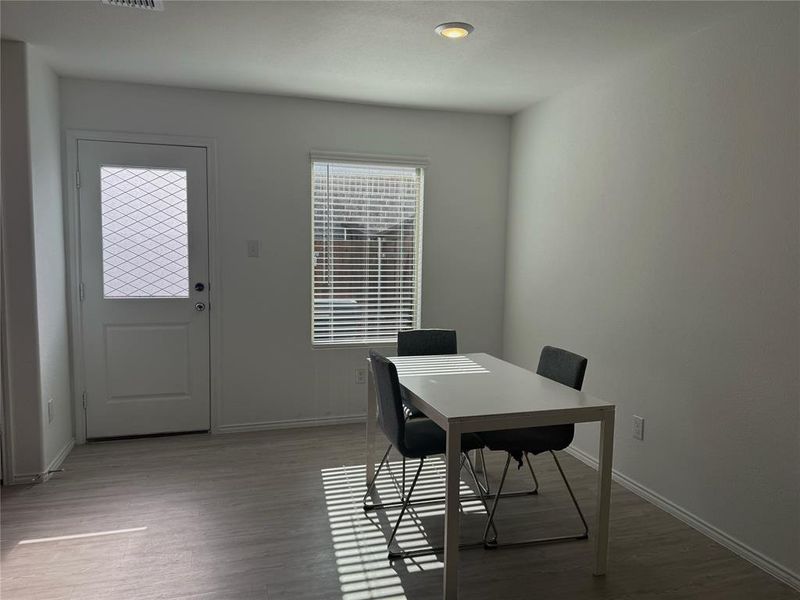 Dining area featuring wood-finish flooring and a window with blinds Dining area featuring wood-finish flooring and a window with blinds