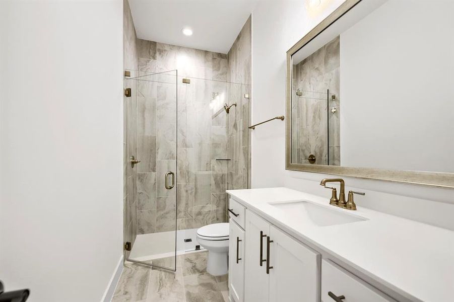 Bathroom featuring a glass-enclosed shower with tiled walls and a recessed niche Bathroom featuring a glass-enclosed shower with tiled walls and a recessed niche