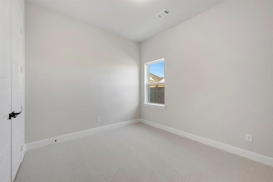 Carpeted spare room featuring baseboards
