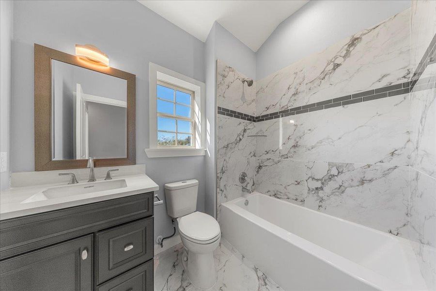 Bathroom with shower / bathtub combination, vanity, and light marble finish flooring Bathroom with shower / bathtub combination, vanity, and light marble finish flooring