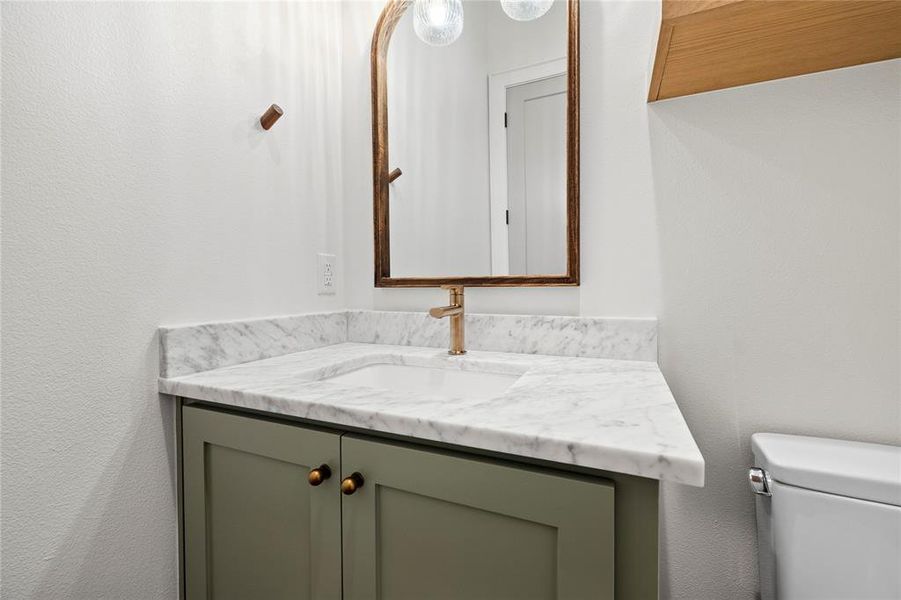 Bathroom with a textured wall and vanity