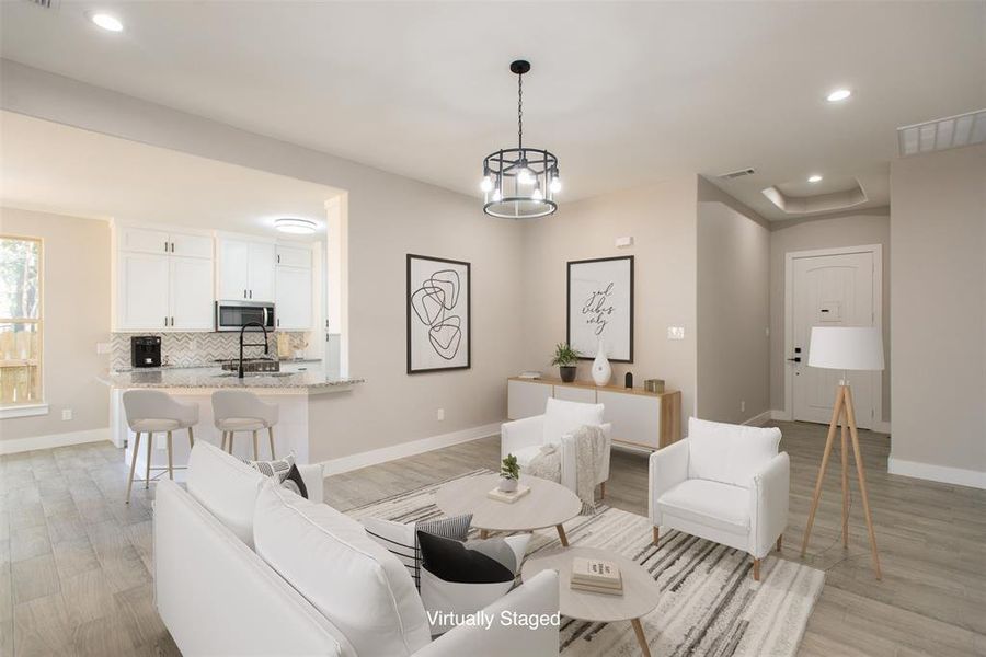 Living room featuring light wood-type flooring and an inviting chandelier