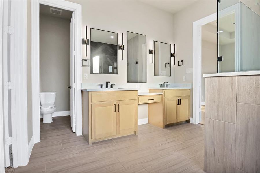 Bathroom featuring hardwood / wood-style floors, vanity, walk in shower, and toilet