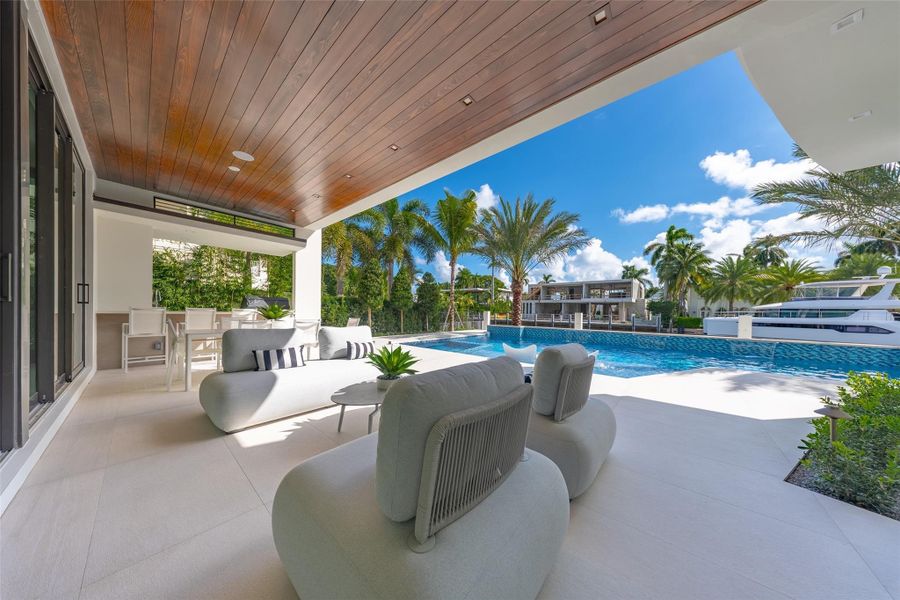 covered patio, providing a shaded, relaxing space to enjoy the waterfront views and tropical landscaping.