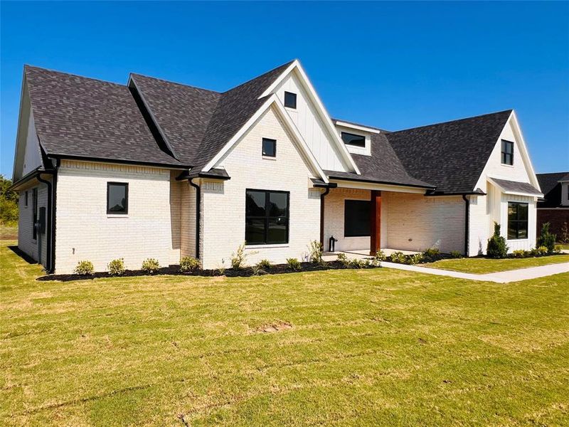 Modern farmhouse style home featuring a front yard