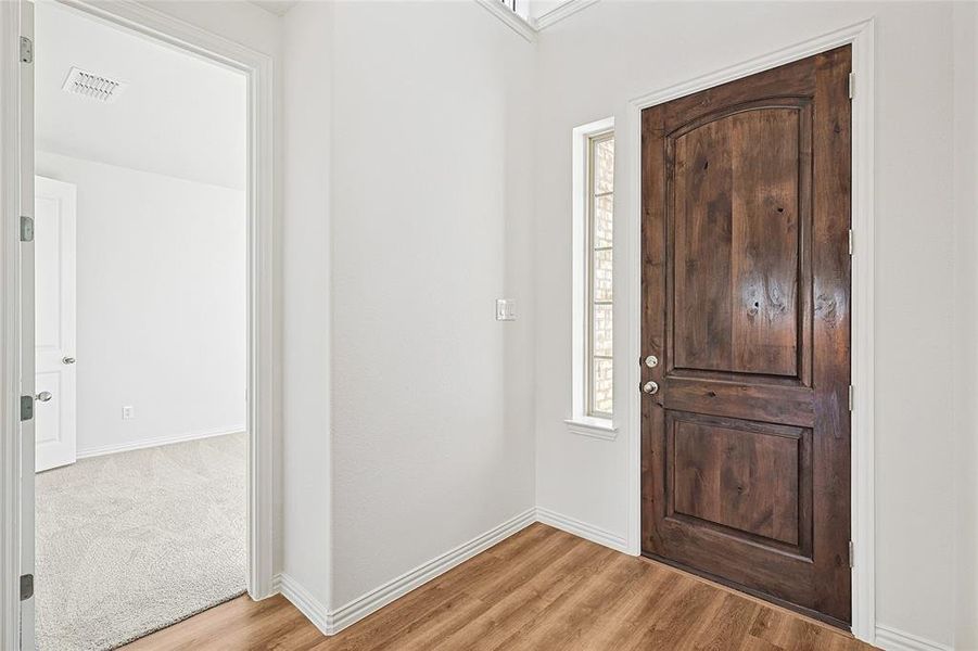 Foyer entrance with healthy amount of natural light and light wood-type flooring