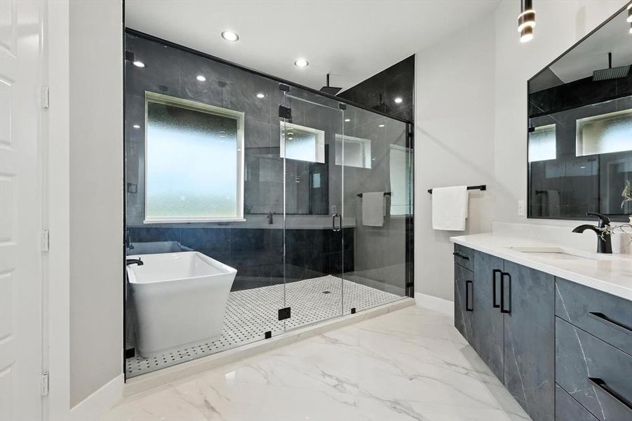 Full bathroom with a stall shower, vanity, a soaking tub, marble tiled flooring, and recessed lighting