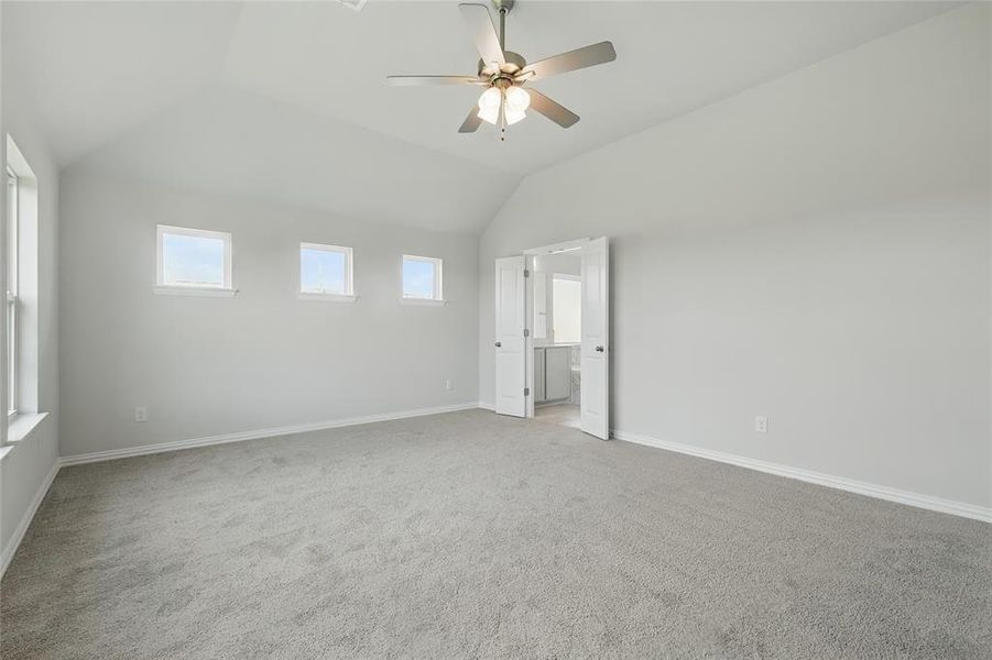 Unfurnished bedroom featuring light carpet, ceiling fan, and vaulted ceiling Unfurnished bedroom featuring light carpet, ceiling fan, and vaulted ceiling