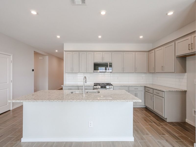 A kitchen with white cabinets.