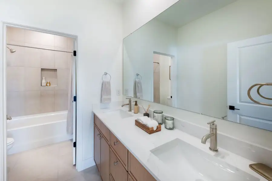 A well-appointed guest bathroom featuring warm finishes and a comfortable design that complements the home’s modern aesthetic. A well-appointed guest bathroom featuring warm finishes and a comfortable design that complements the home’s modern aesthetic.