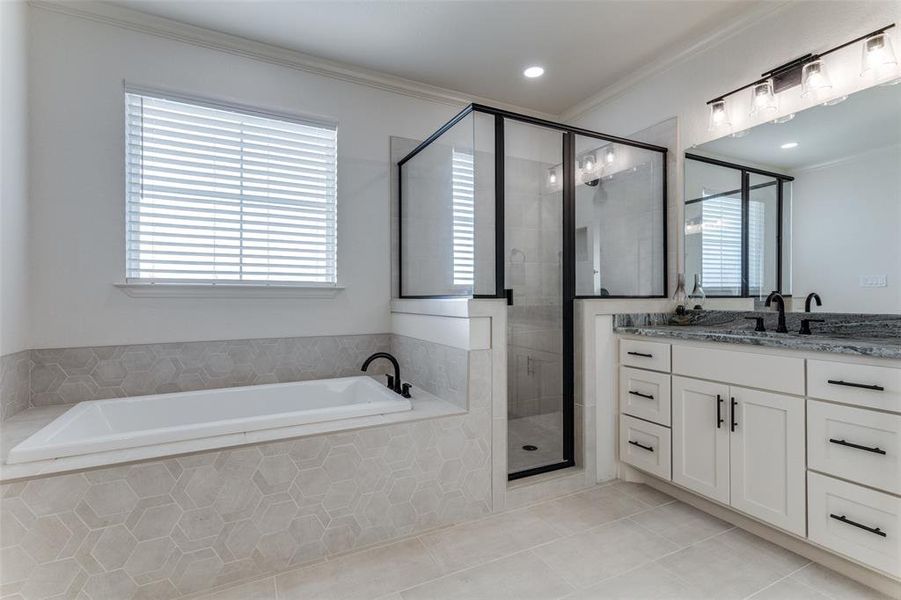 Bathroom with tile patterned flooring, vanity, a garden tub, a stall shower, and ornamental molding