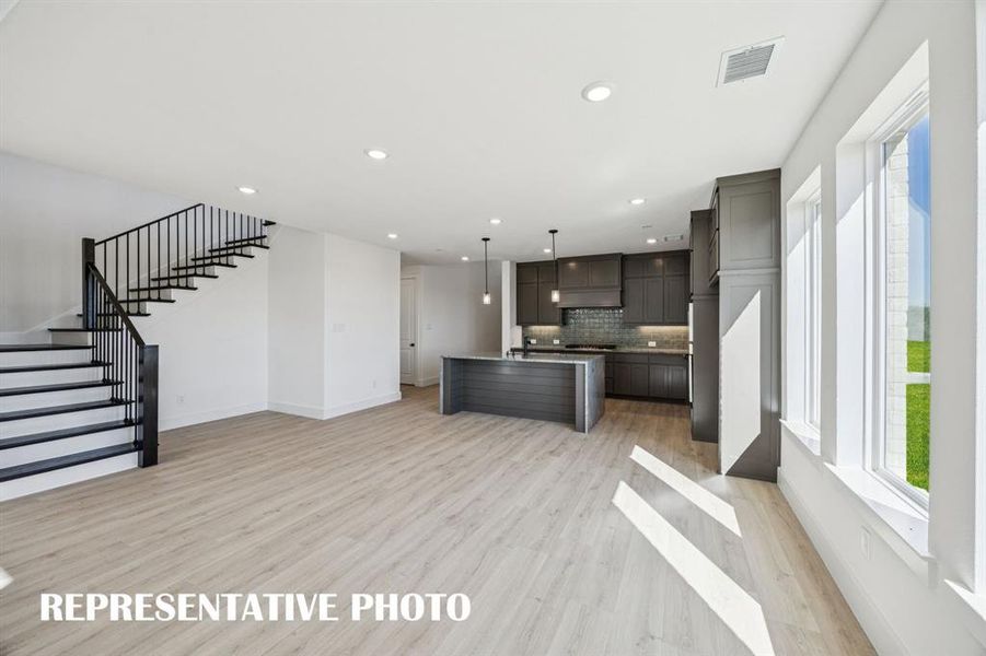 Featuring a view to the outdoors through a wall of windows, this dining room is the perfect setting for lively dinner parties or cozy family meals!  REPRESENTATIVE PHOTO