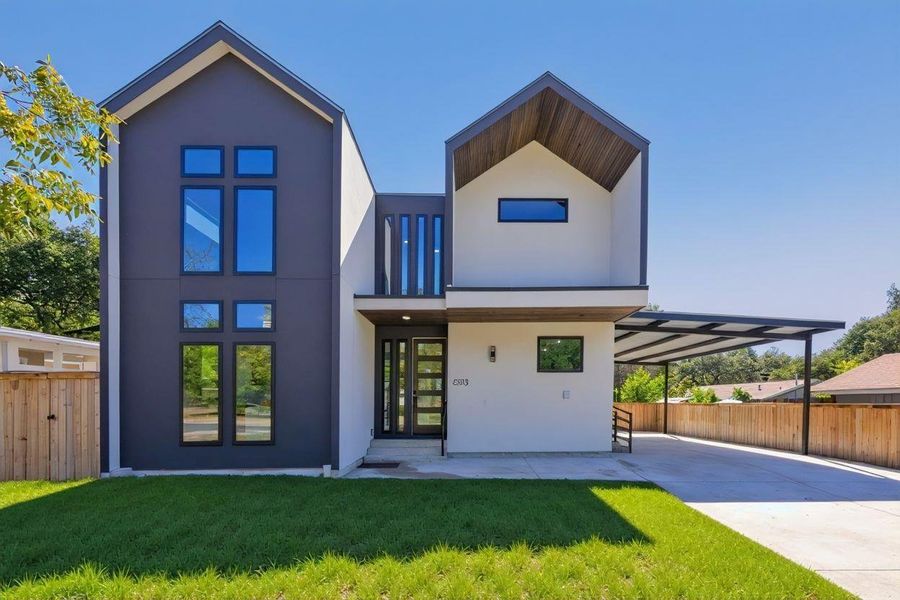 View of front of home featuring stucco siding, concrete driveway, and a patio- grass virtually enhanced View of front of home featuring stucco siding, concrete driveway, and a patio- grass virtually enhanced