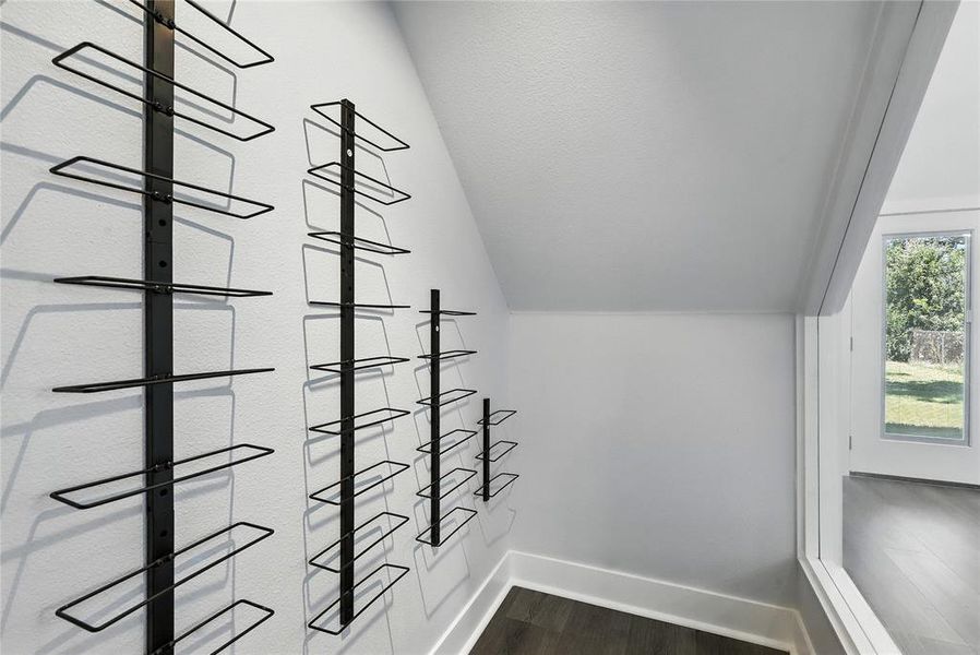 Spacious closet featuring lofted ceiling and dark wood-style flooring