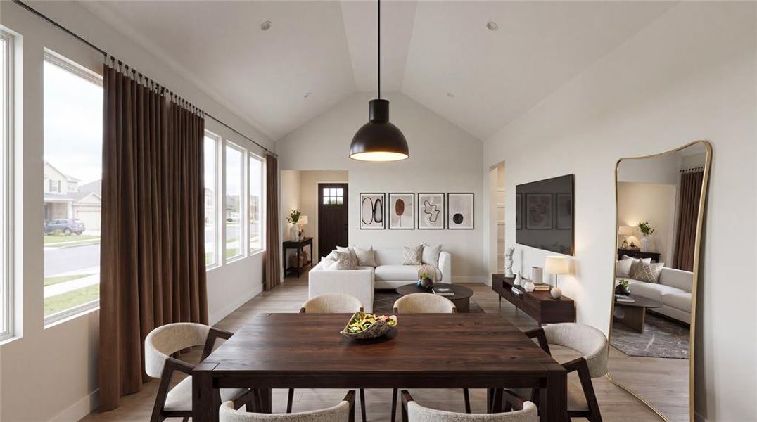 Vaulted ceiling dining area featuring wood-finish flooring, a contemporary pendant light fixture, and a large window array with full-length curtains