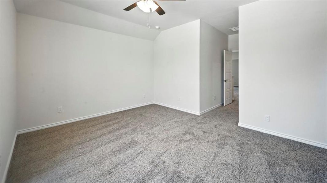 Unfurnished room with carpet floors, ceiling fan, and vaulted ceiling