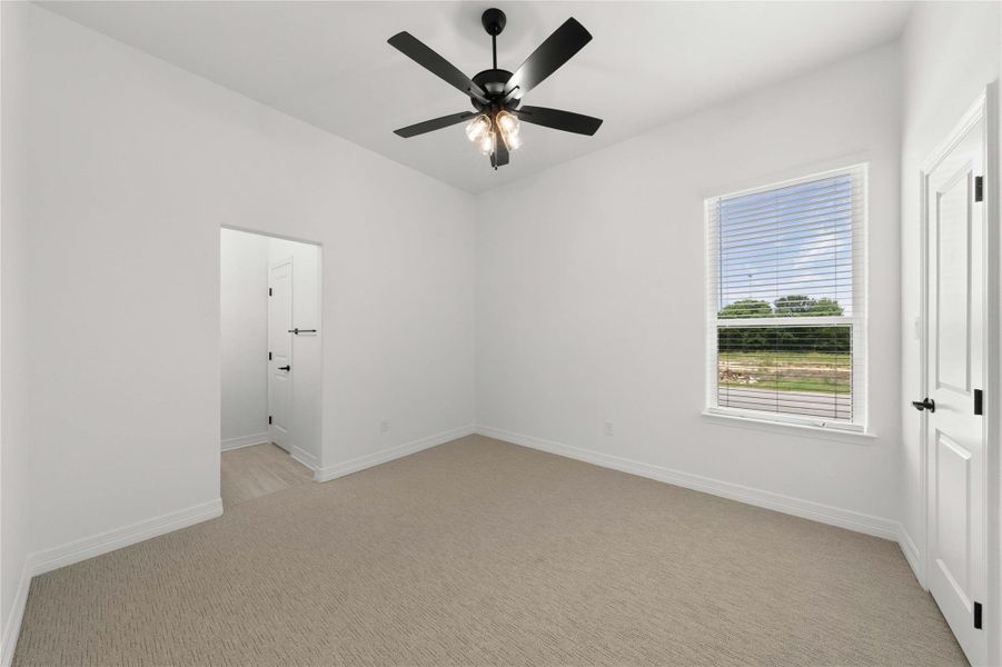 A well-lit room offers comfort and simplicity, with a ceiling fan providing gentle air circulation. A well-lit room offers comfort and simplicity, with a ceiling fan providing gentle air circulation.