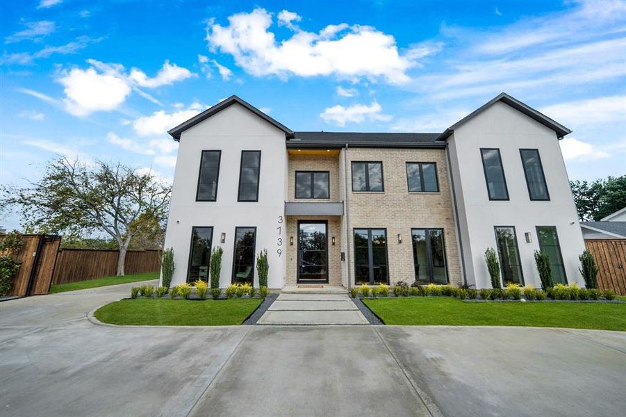 Modern home featuring brick siding and stucco siding