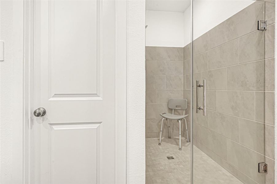 Modern bathroom featuring a spacious walk-in shower with sleek tilework and a convenient seating area. Modern bathroom featuring a spacious walk-in shower with sleek tilework and a convenient seating area.