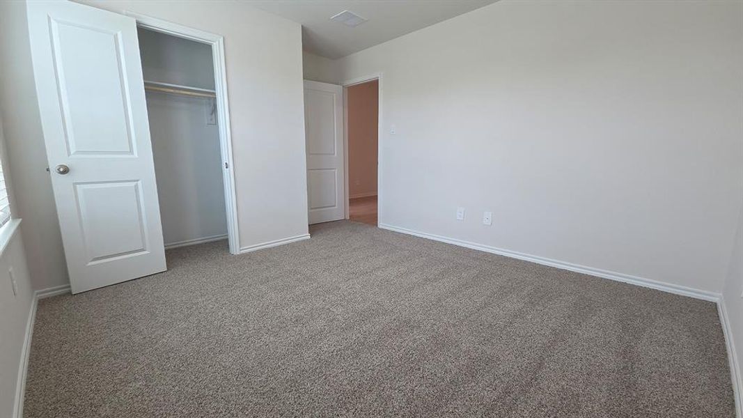 Carpeted interior space featuring light neutral wall paint