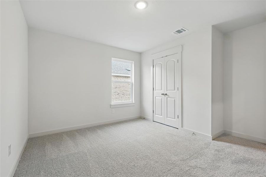 Unfurnished bedroom featuring light carpet and a closet Unfurnished bedroom featuring light carpet and a closet