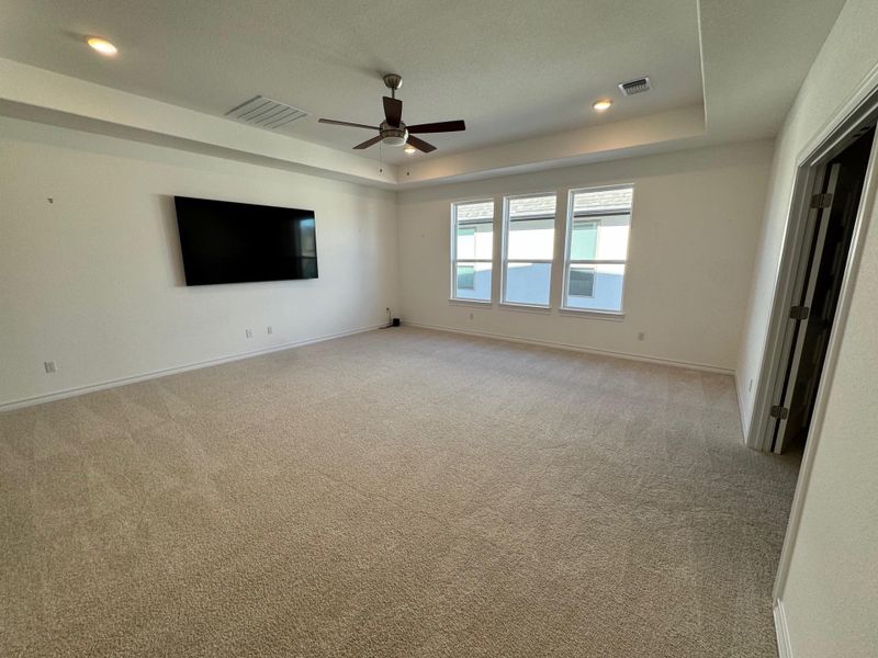 Second floor family room featuring a tray ceiling, light colored carpet, a ceiling fan, and recessed lighting