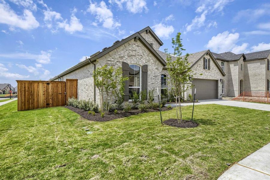 Brick exterior residence featuring an attached two-car garage, manicured front lawn, and mature landscaping Brick exterior residence featuring an attached two-car garage, manicured front lawn, and mature landscaping