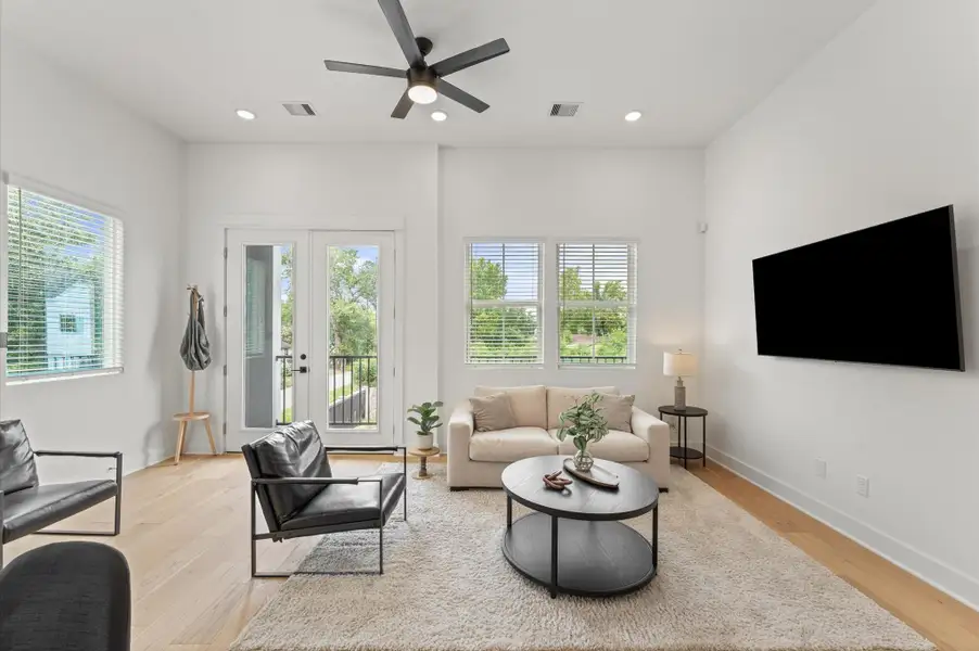 Airy and inviting open-concept living space located on the second floor, thoughtfully designed to enhance both comfort and flow. The area features high ceilings, expansive windows, and cohesive flooring that unify the living, dining, and kitchen zones. Elegant French doors serve as a striking focal point, leading out to a private balcony that extends the living space outdoors—perfect for morning coffee or evening unwinding. Airy and inviting open-concept living space located on the second floor, thoughtfully designed to enhance both comfort and flow. The area features high ceilings, expansive windows, and cohesive flooring that unify the living, dining, and kitchen zones. Elegant French doors serve as a striking focal point, leading out to a private balcony that extends the living space outdoors—perfect for morning coffee or evening unwinding.