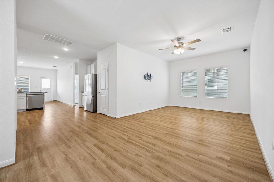 Unfurnished living room featuring a ceiling fan and light wood-style flooring