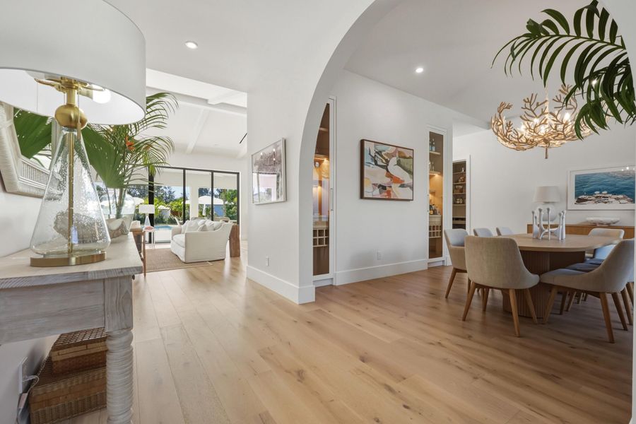 Dramatic arched entry to dining room complete with Serena & Lilly chandelier, & built-in wine storage